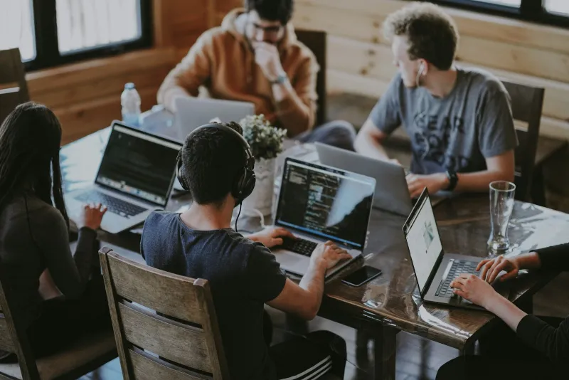 Entwicklerteam arbeitet gemeinsam an Laptops